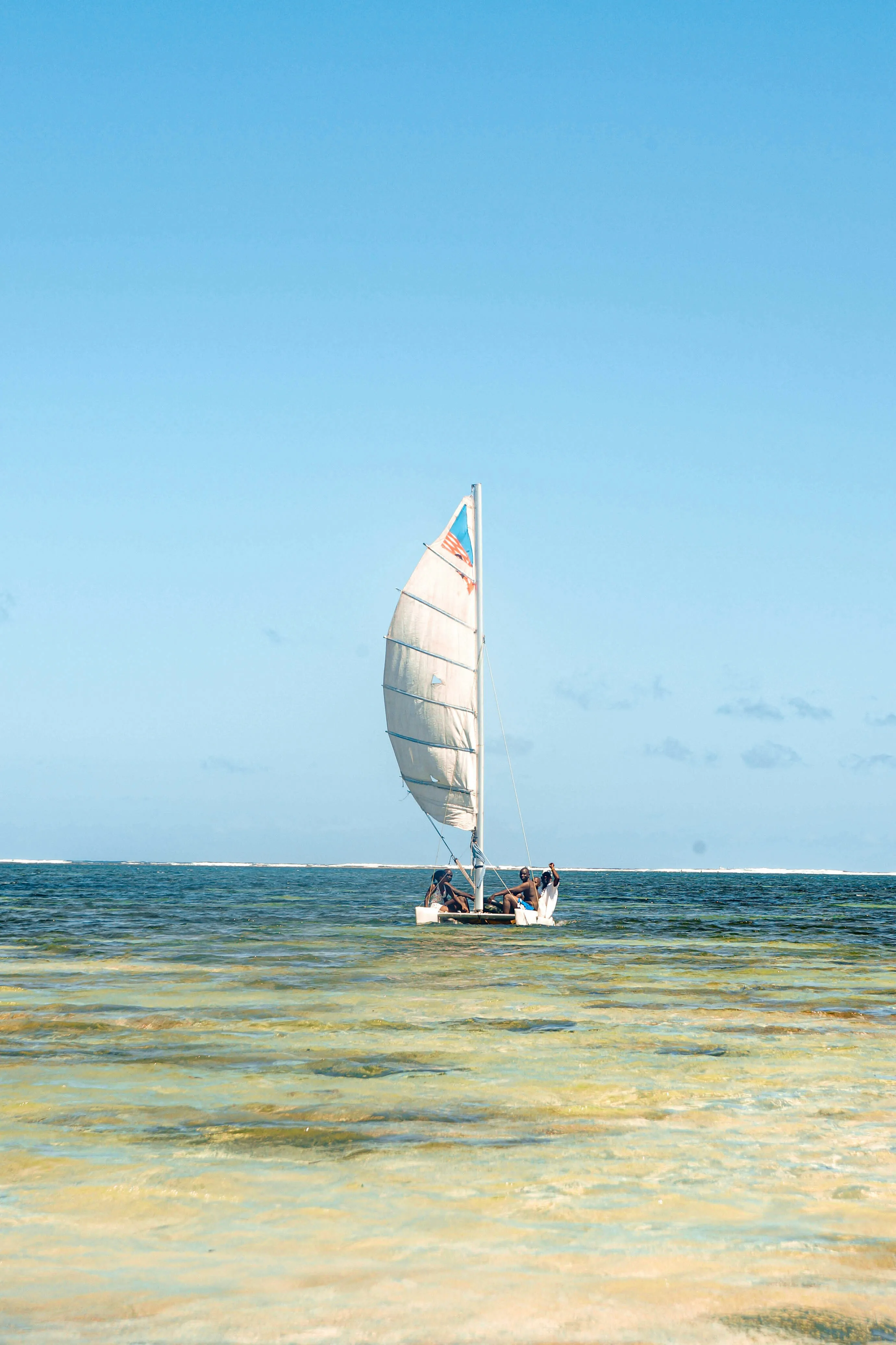 A small sailing dhow on the water off the Kenyan coast.