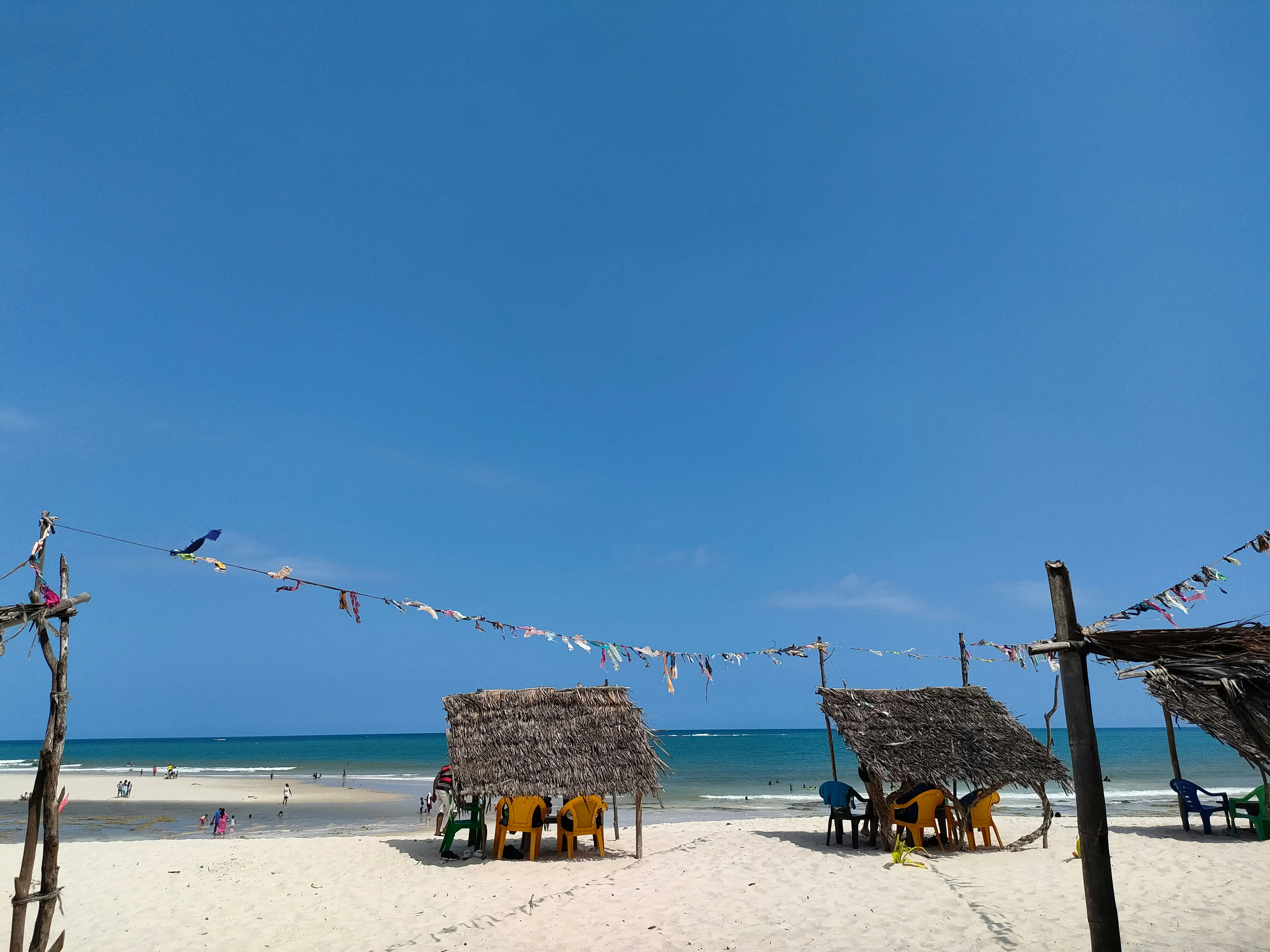 Thatched beach bandas and loungers on white sand at Diani.